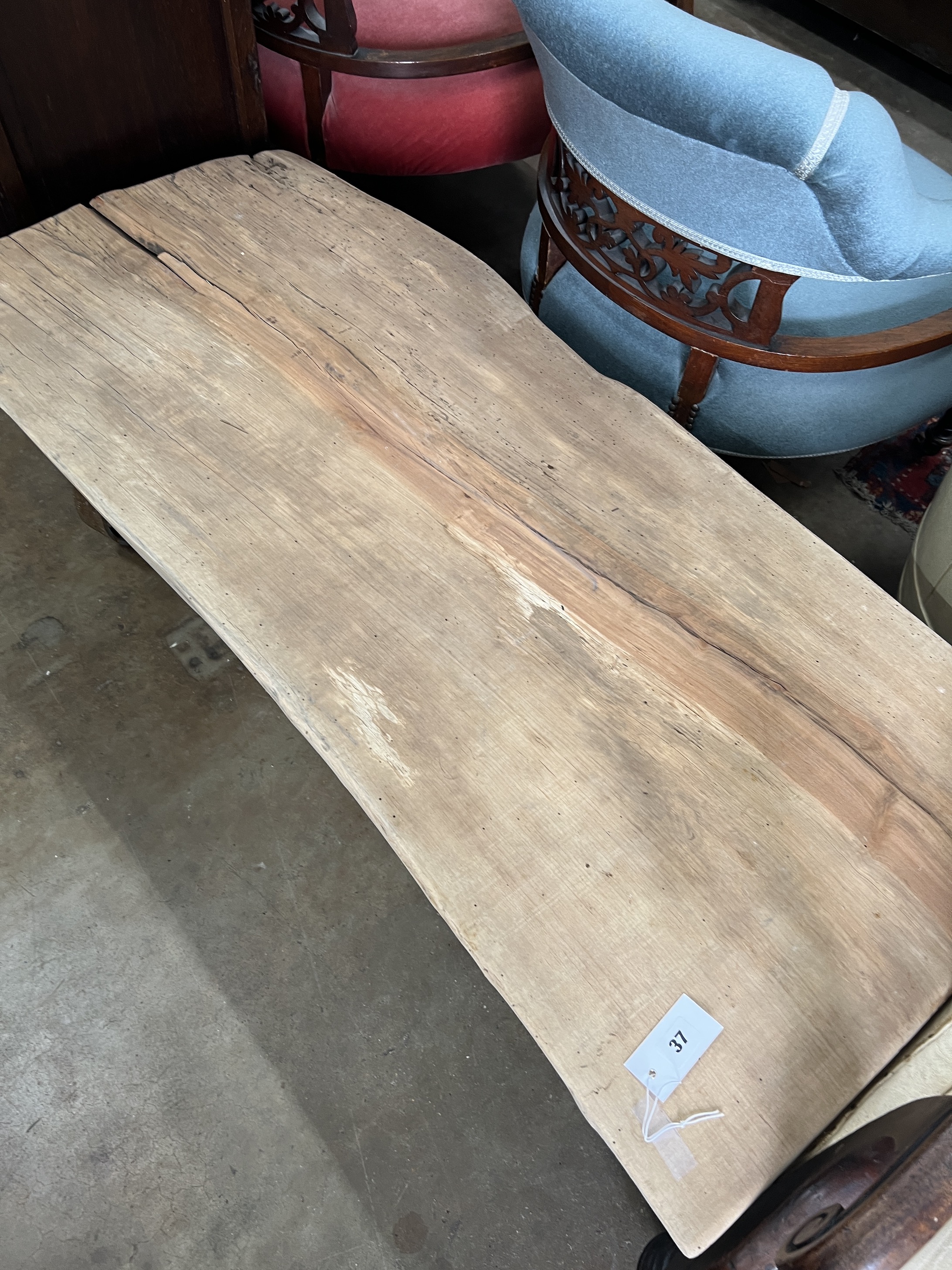 An industrial style rectangular waney edge plank top coffee table on spoked wheel base, width 122cm, depth 53cm, height 39cm